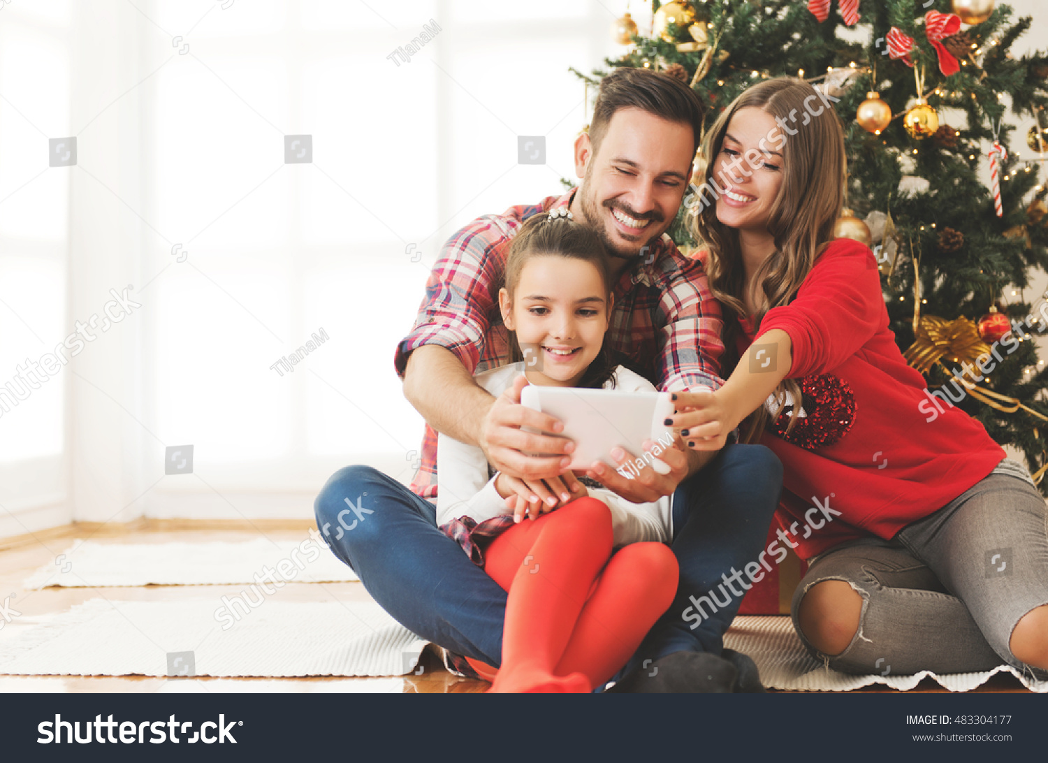 Familia reunida alrededor del árbol de Navidad