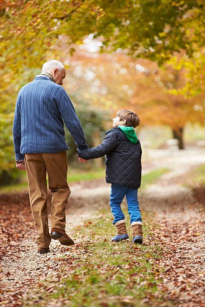 Abuelo y nieto caminando juntos de la mano